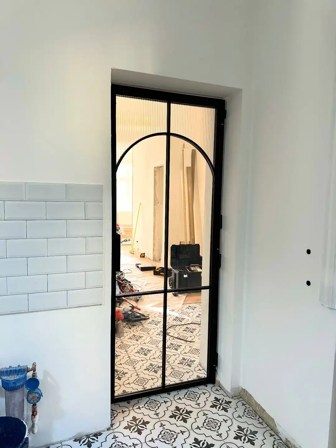 Ușă tip loft cu arcadă interioară, cadru metalic negru și sticlă canelată